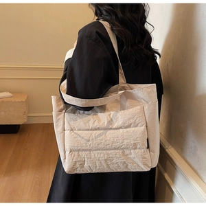 Quilted tote bag in cream white fabric shown on model for size and casual style