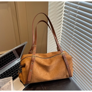 Detail of vintage brown suede shoulder bag with adjustable leather strap and gold buckle