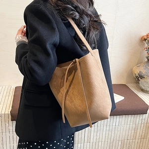 Detail shot of vintage brown suede bucket bag texture with shoulder strap and drawstring