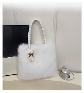 Detail view of white faux fur tote bag with woven handle and plush bear charm