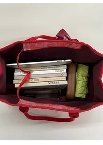 Vue de dessus d'un grand cabas en toile rouge montrant l'espace pour livres et tablette