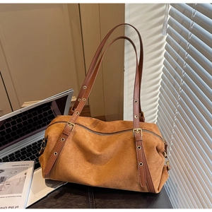 Close-up of vintage brown suede shoulder bag with retro metal eyelets on long straps