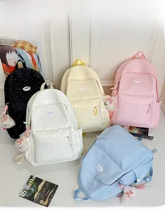 Polka dot canvas backpacks in black, white, pink and blue with plush charms for girls