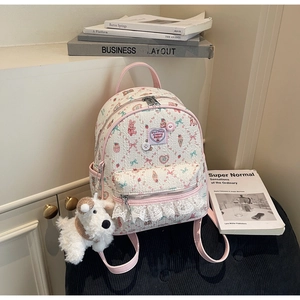 Détail d'un sac à dos mignon avec motifs floraux, dentelle et breloque peluche chien