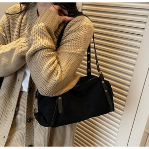 Detail of adjustable leather shoulder strap with metal eyelets and buckle on black tote