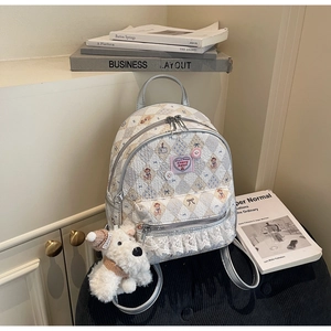 Détail d'un sac à dos floral doux avec dentelle, écusson cœur et pendentif chiot
