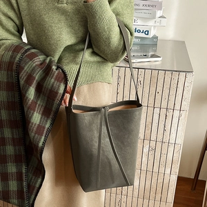 Detail of vintage suede bucket bag with leather drawstring and slim shoulder strap