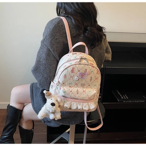 Détail d'un sac à dos mignon imprimé cerise avec dentelle et peluche de chiot