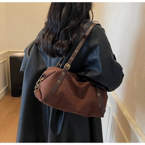 Detail view of suede cylinder Boston bag with premium brown leather strap and gold buckle