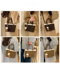 Detail view of suede bucket bag with faux shearling trim and cute glove pendant accessory