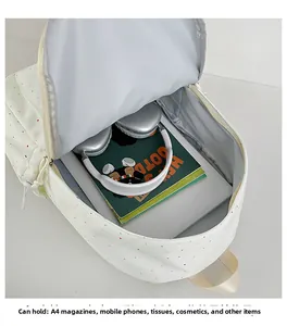 Detailed interior of polka dot backpack showing capacity for A4 books and headphones