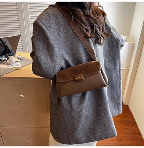 Detail of coffee brown crossbody bag showing suede flap and smooth leather texture