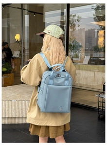 Detail of light blue backpack with twill texture and side pocket on a street model