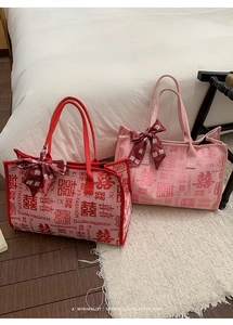 Gros plan des sacs de mariée en toile rouge et rose avec nœud en soie et imprimé double bonheur