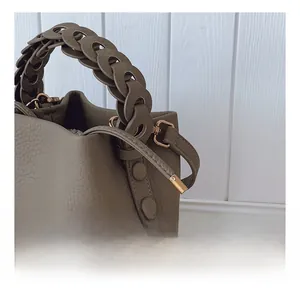 Détail du sac seau vert-gris foncé avec poignée tressée et crochet en métal doré