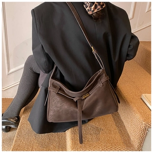 Détail du sac cabas en cuir mat marron foncé avec plis et boucle métallique