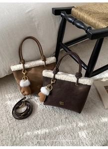 Detail of suede bucket bags with shearling trim and cute glove-shaped fuzzy charms