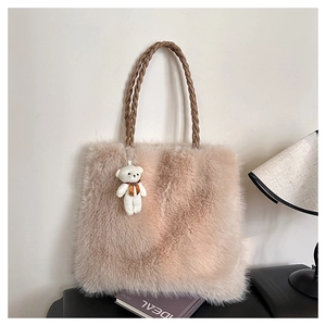 Close-up of fluffy faux fur tote bag with braided handles and a teddy bear charm