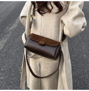 Detail of dark brown PU leather crossbody bag with suede flap and jacquard strap