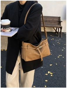 Sac fourre-tout rétro en cuir mat marron porté par un mannequin en style vintage