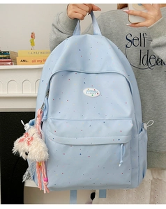 Detail of light blue polka dot backpack with a cute white plush bunny charm