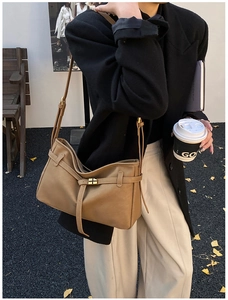 Détail du sac cabas en cuir marron avec boucle latérale et bandoulière réglable