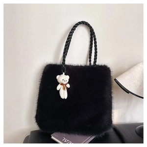 Detail of black faux fur tote bag with plush texture and cute white bear keychain
