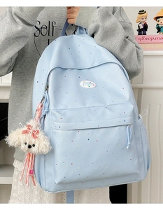 Detail of light blue polka dot backpack with water-resistant fabric and plush dog charm