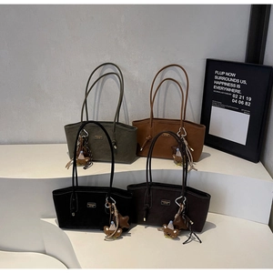 Détail de quatre sacs fourre-tout en daim minimalistes en vert, camel, noir et marron