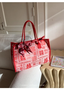 Détail du sac cabas de mariée rouge tissé avec motif Double Bonheur et nœud en soie rouge