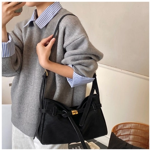 Gros plan sur un sac cabas noir avec boucle dorée élégante et détails de sangle