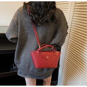 Red lychee grain leather dumpling bag shown with adjustable shoulder strap and top handle