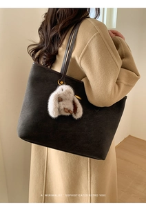 Détail du sac cabas gris foncé en daim avec breloque lapin sur manteau d'hiver
