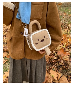 Close-up of cute toast-shaped plush crossbody bag with embroidery on autumn leaves