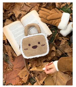 Detail of plush brown square bag with soft white faux fur trim and cute embroidery