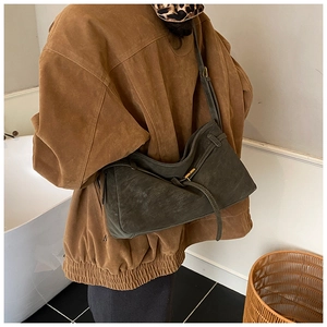 Détail d'un sac cabas vintage en cuir mat avec boucle dorée et texture sophistiquée