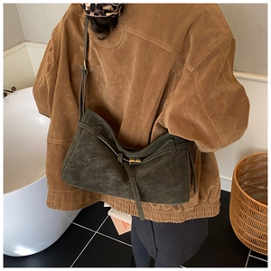Détail du sac fourre-tout vintage en daim vert foncé avec boucle dorée et fine bandoulière