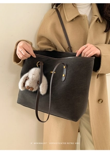 Détail du sac cabas minimaliste avec breloque lapin en peluche sur un manteau