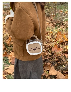 Close-up of brown suede mini square bag with plush trim and cute cartoon embroidery