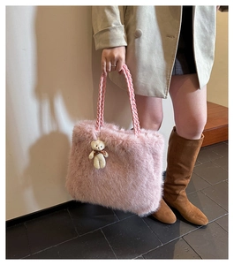 Pink plush tote bag with a cute bear pendant worn by a model in a beige coat