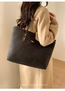 Macro detail of large retro suede tote bag with golden rivets and a stylish shoulder strap