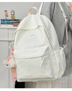 Polka dot white backpack with plush dog charm and side water bottle pocket view