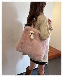 Close-up of pink faux fur tote bag featuring a cute white bear pendant and woven strap