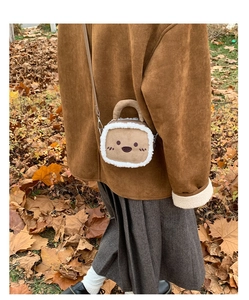 Detail of plush brown suede crossbody bag with fluffy sheepskin trim and cute animal face