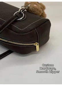 Detail of vintage brown leather bag with custom hardware, smooth zipper and white stitching