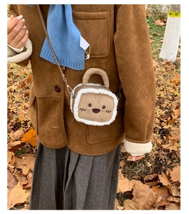 Detail of a brown suede mini square bag with white faux shearling trim and cute embroidery