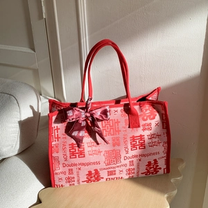 Détail du cabas de mariée rouge avec motif de double bonheur et nœud satin