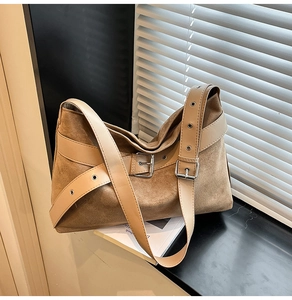 Détail du sac hobo en suédine mate avec large bandoulière en cuir et boucles argentées