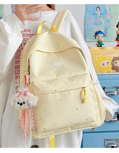 Polka dot canvas backpack for women featuring a cute plush dog charm on side
