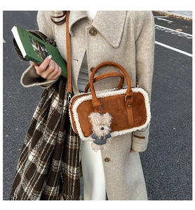 Photo lifestyle d'un sac carré en daim marron avec bordure en fourrure et breloque ours